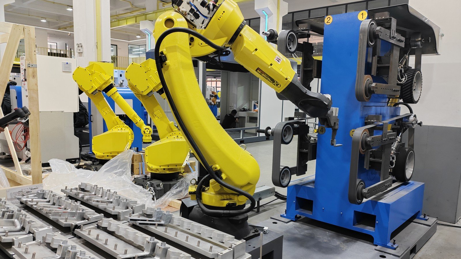 Robotic belt grinding system processing cast metal parts