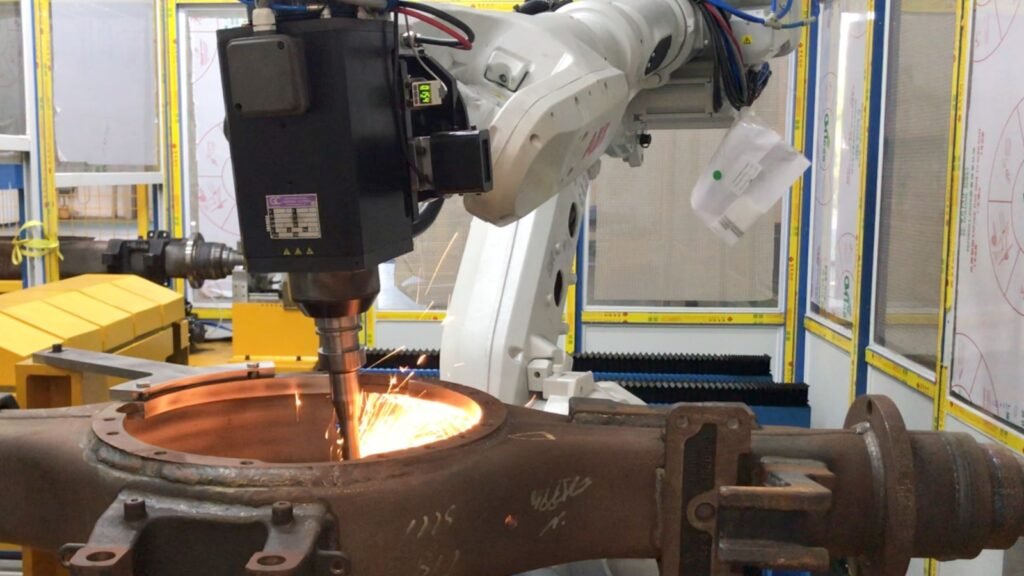 Robot-mounted deburring tool approaching an edge on a metal component